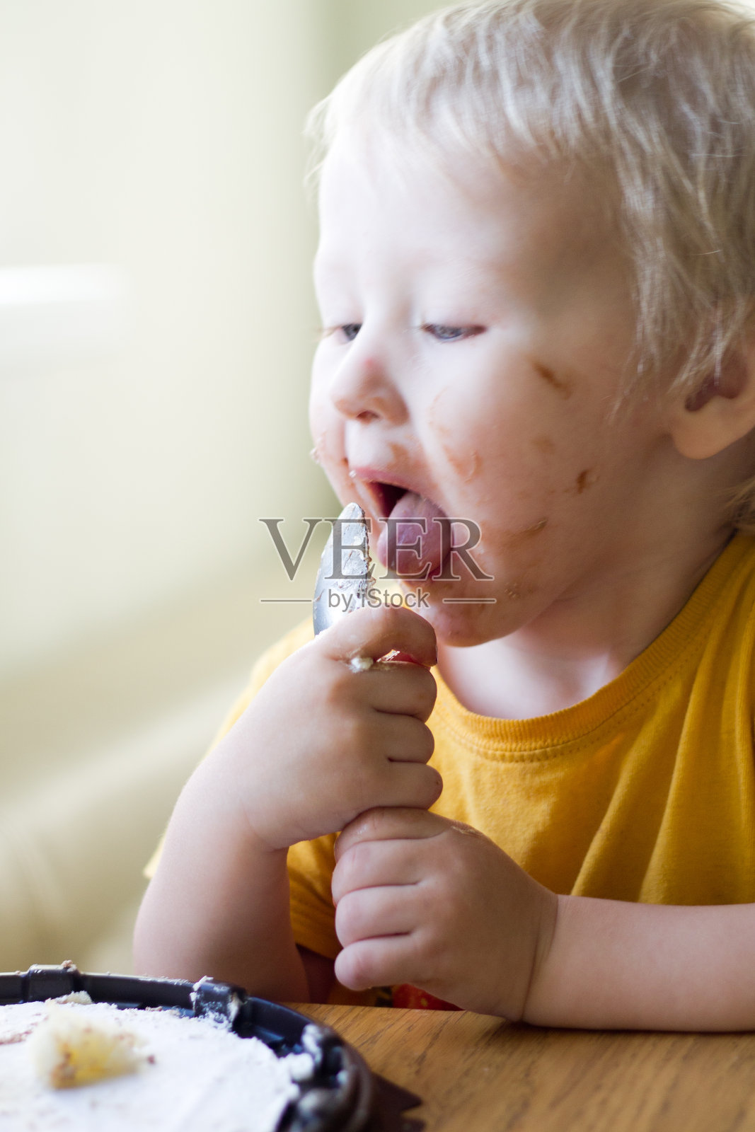 这孩子把蛋糕弄得一团糟，弄脏了所有的泥土照片摄影图片