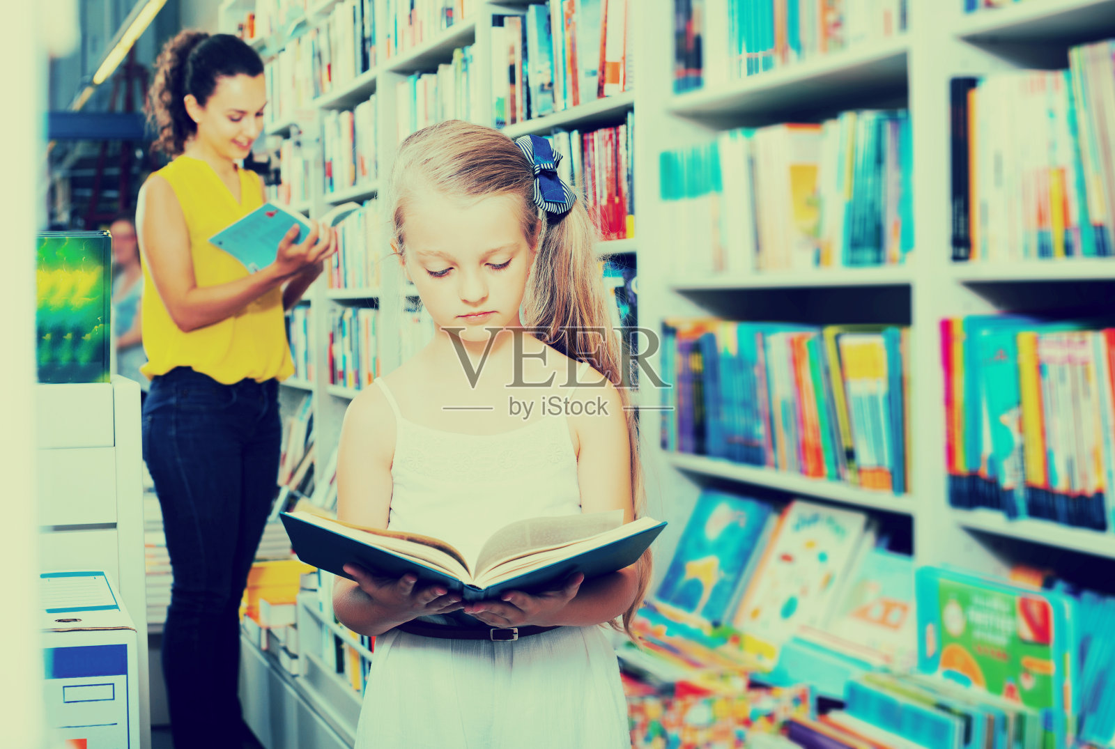 女孩在书店里读课本照片摄影图片