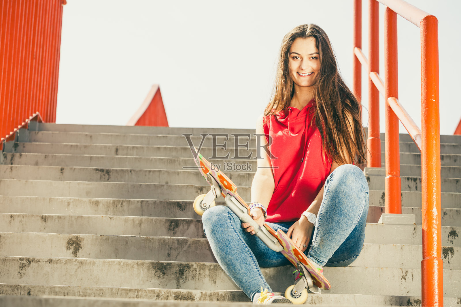 在楼梯上玩滑板的女孩。照片摄影图片