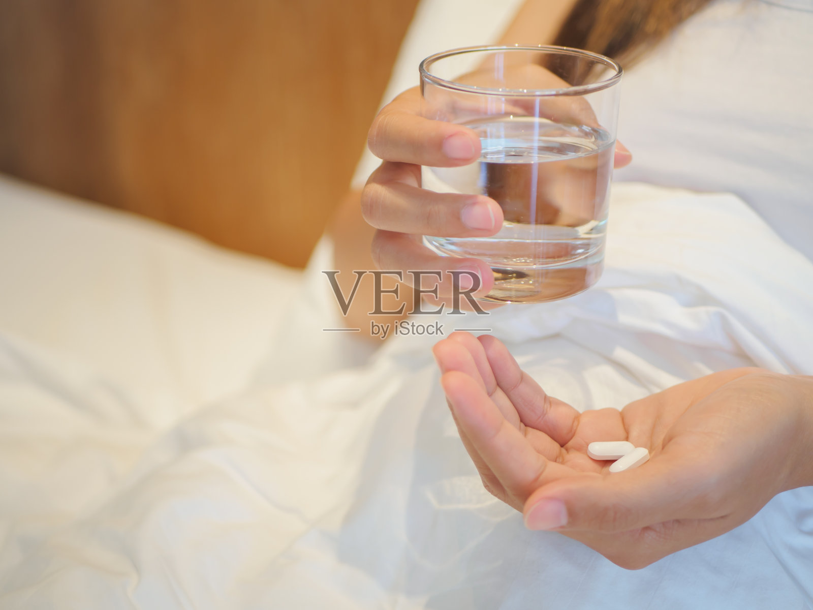 近距离观察女性服用选择性聚焦药丸。以人为本、医学保健理念。照片摄影图片