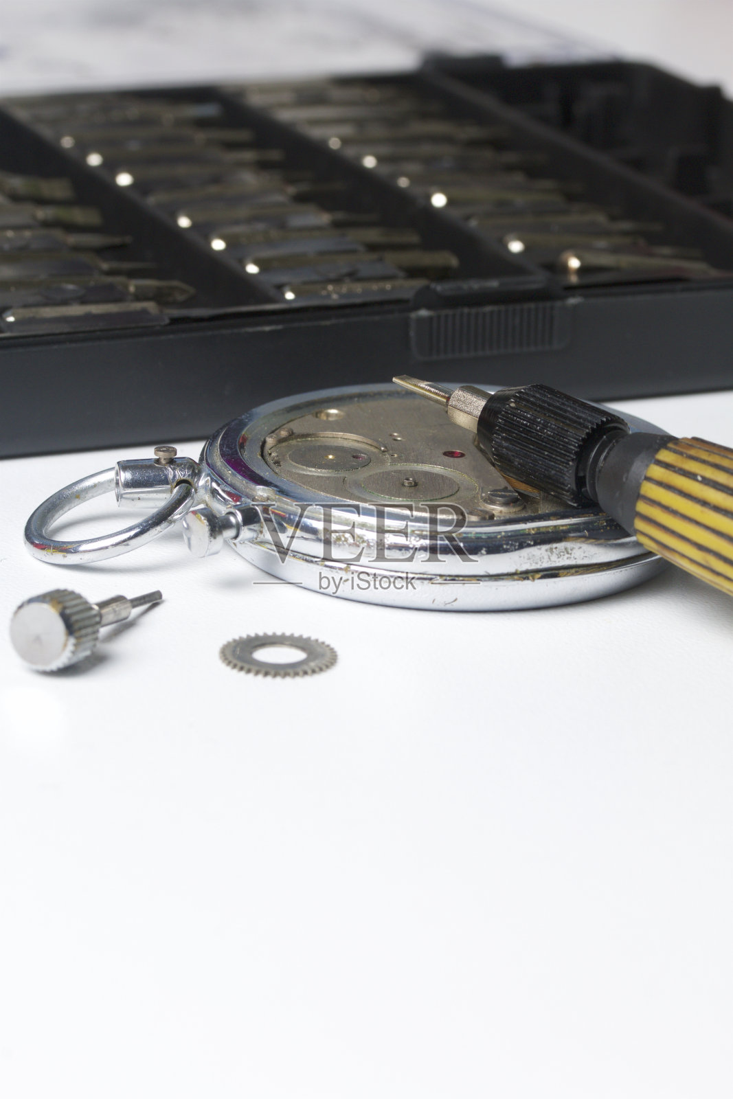 手表车间。修理旧手表。钟表的机械装置，螺丝刀，是师傅用来修理的。在白色的背景上。照片摄影图片