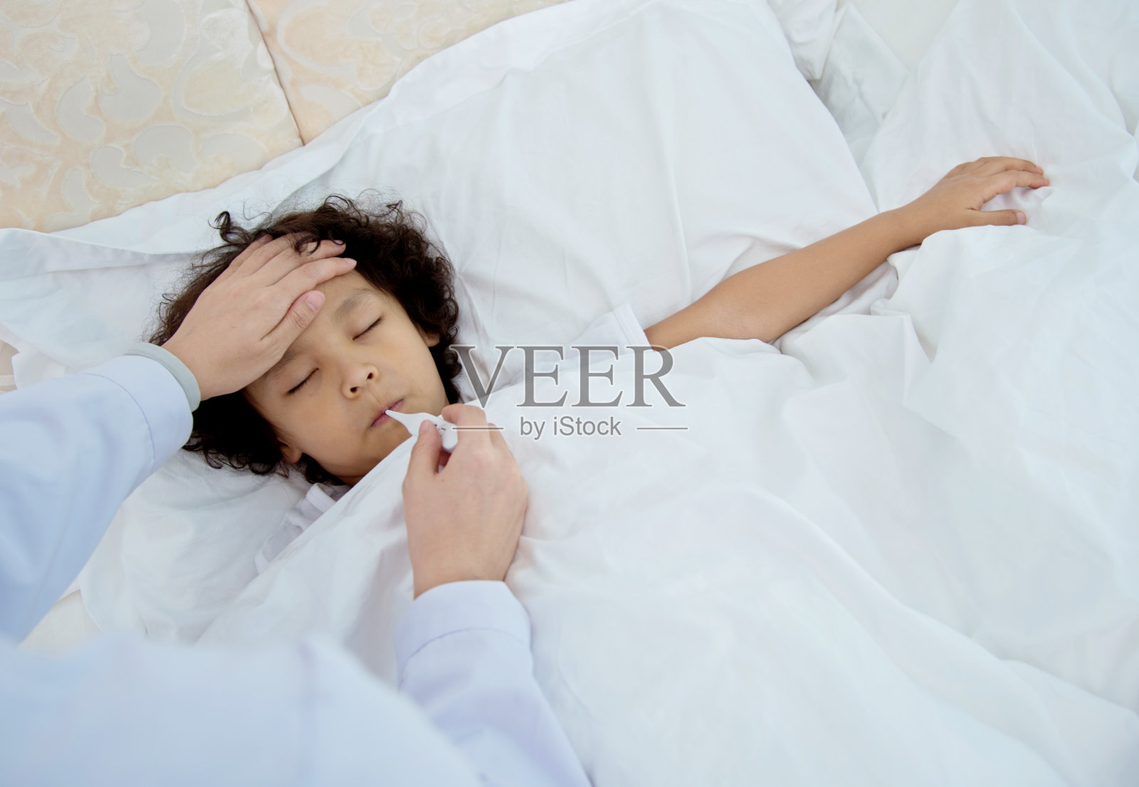 护士在给生病的男孩测体温照片摄影图片