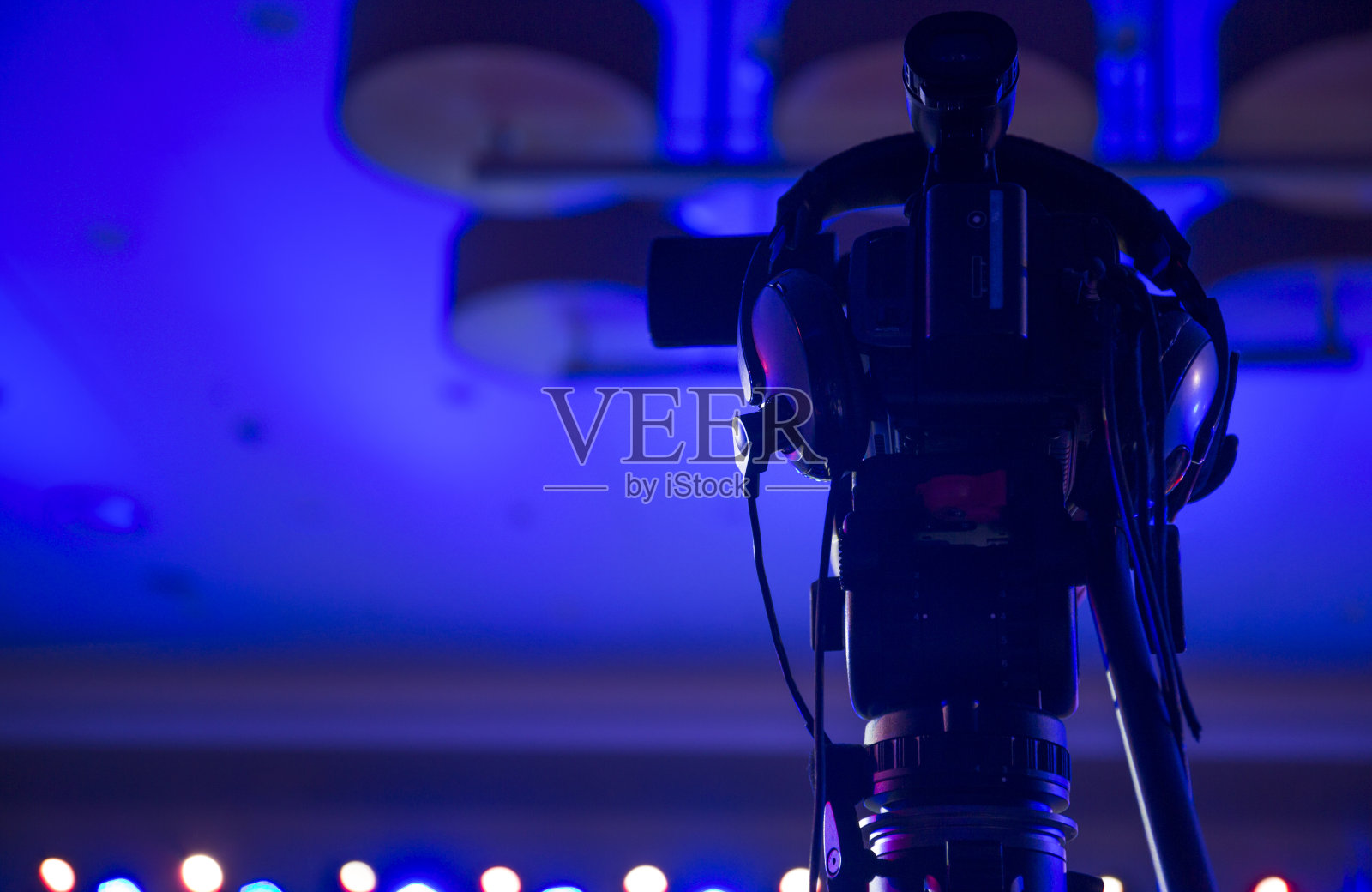 音乐会上带蓝光的相机和耳机。照片摄影图片