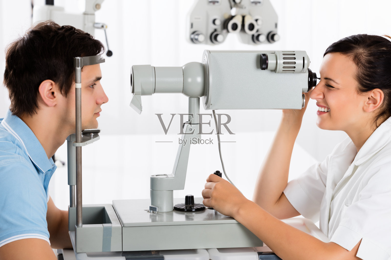 一位验光师正在为男性病人做视力测试照片摄影图片