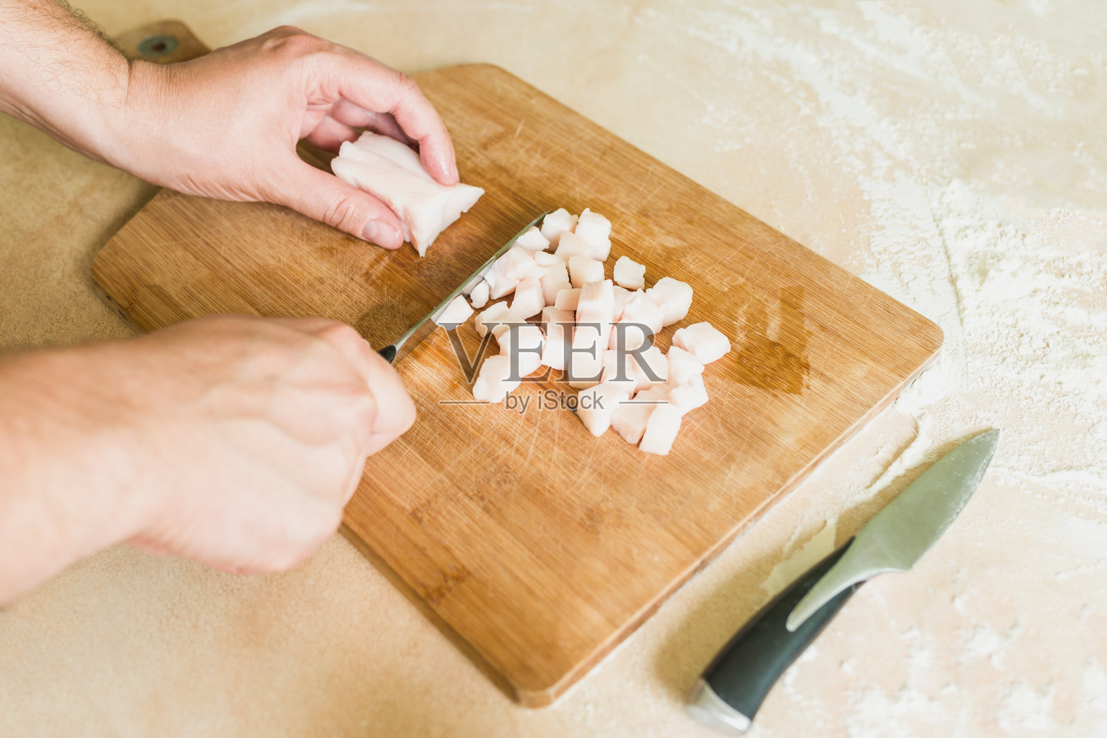 一个男人把生猪油切成小块照片摄影图片