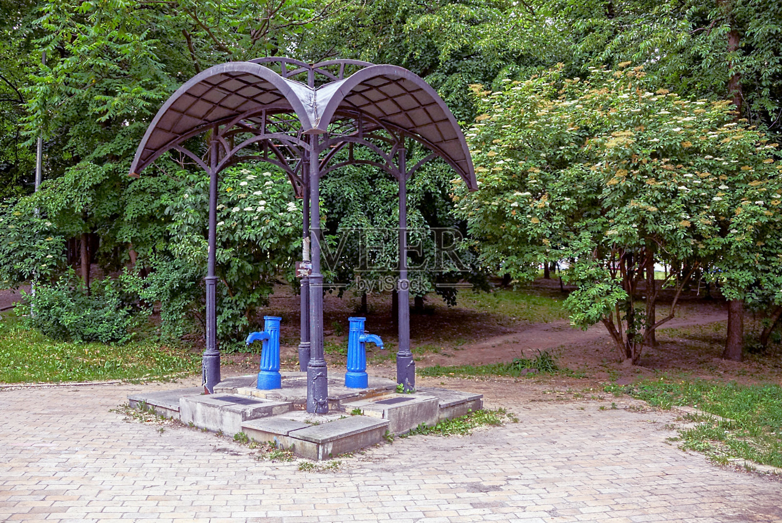 公园内带有蓝色水柱的开放式凉亭照片摄影图片