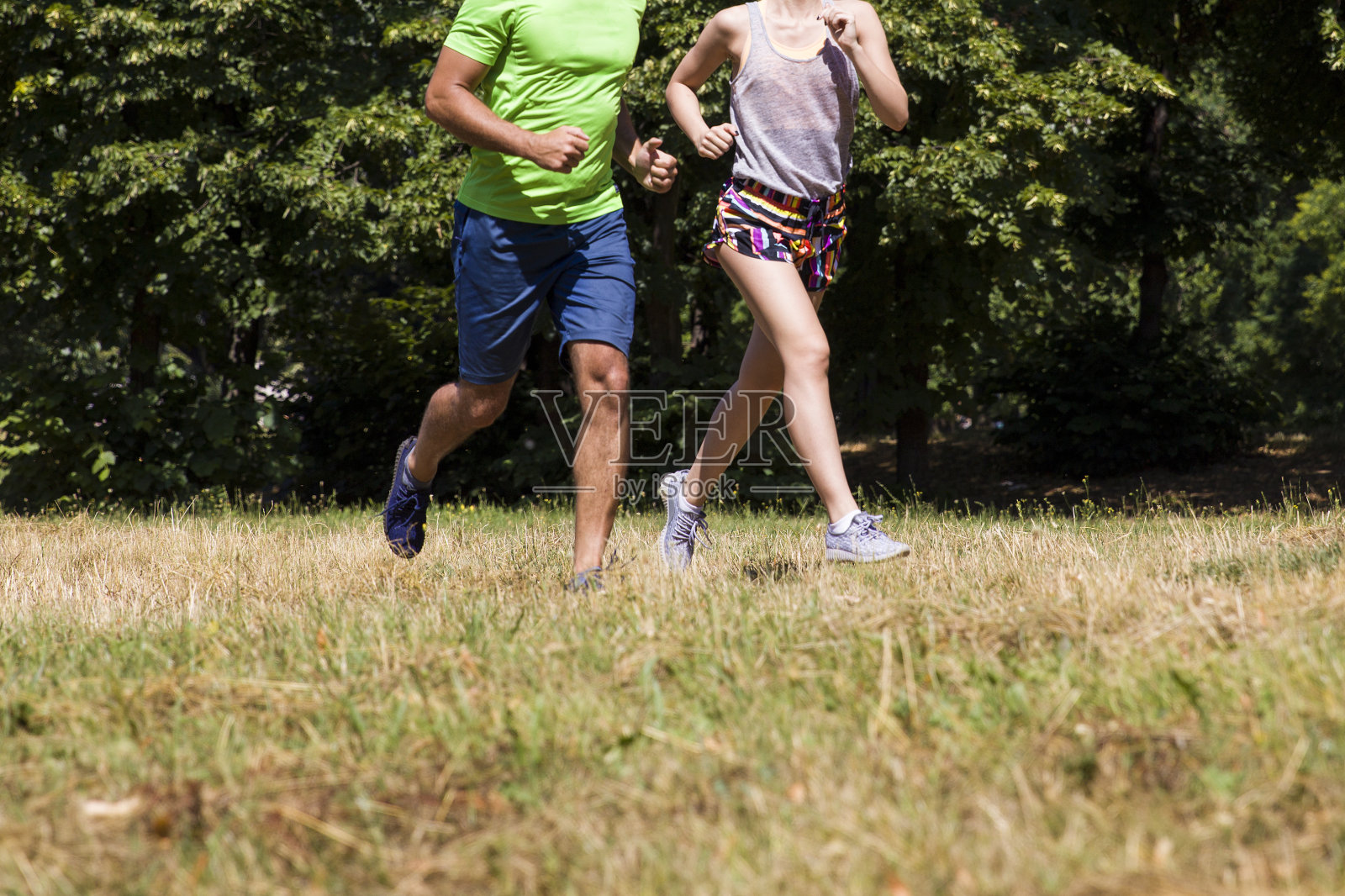 一对年轻夫妇在一个阳光明媚的日子里在公园里跑步照片摄影图片