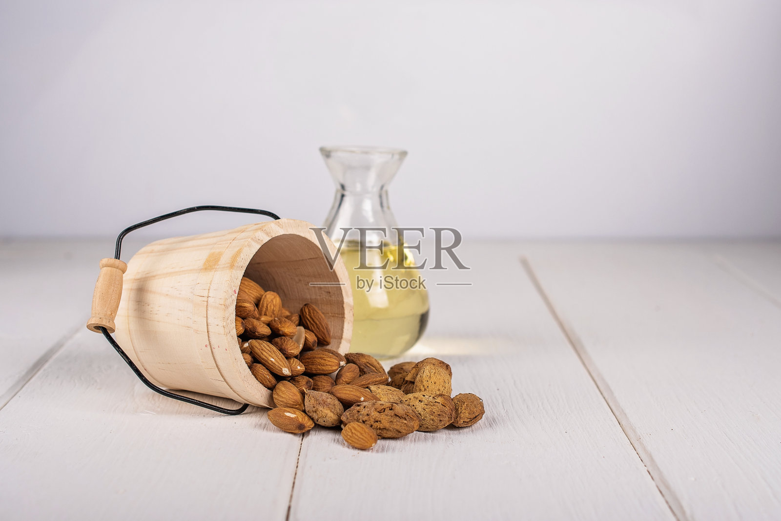 杏仁油和一碗杏仁放在白木上照片摄影图片