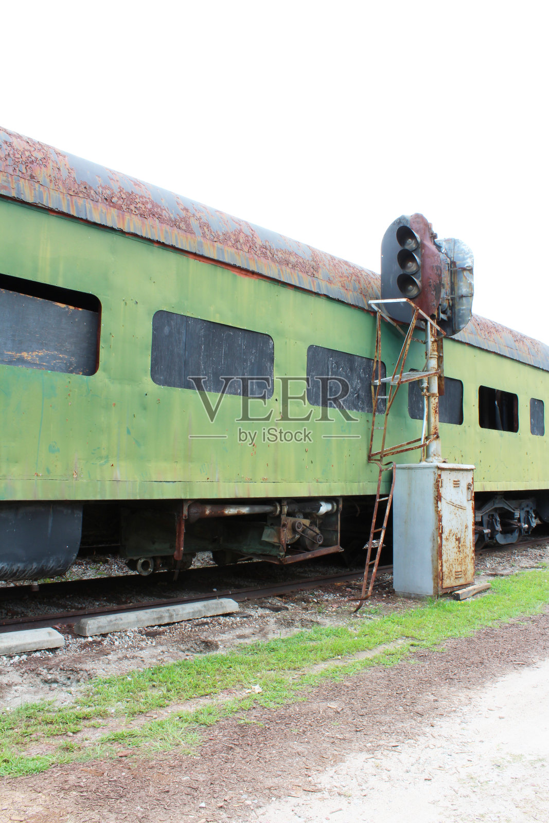 从侧面看一辆生锈的绿色废弃的火车车厢和火车轨道灯具照片摄影图片