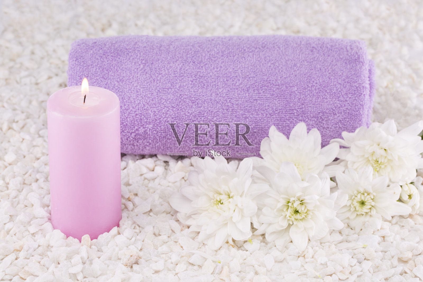 水疗中心。仍然生活。毛巾卷成一卷，粉红色的蜡烛，白色的菊花。照片摄影图片