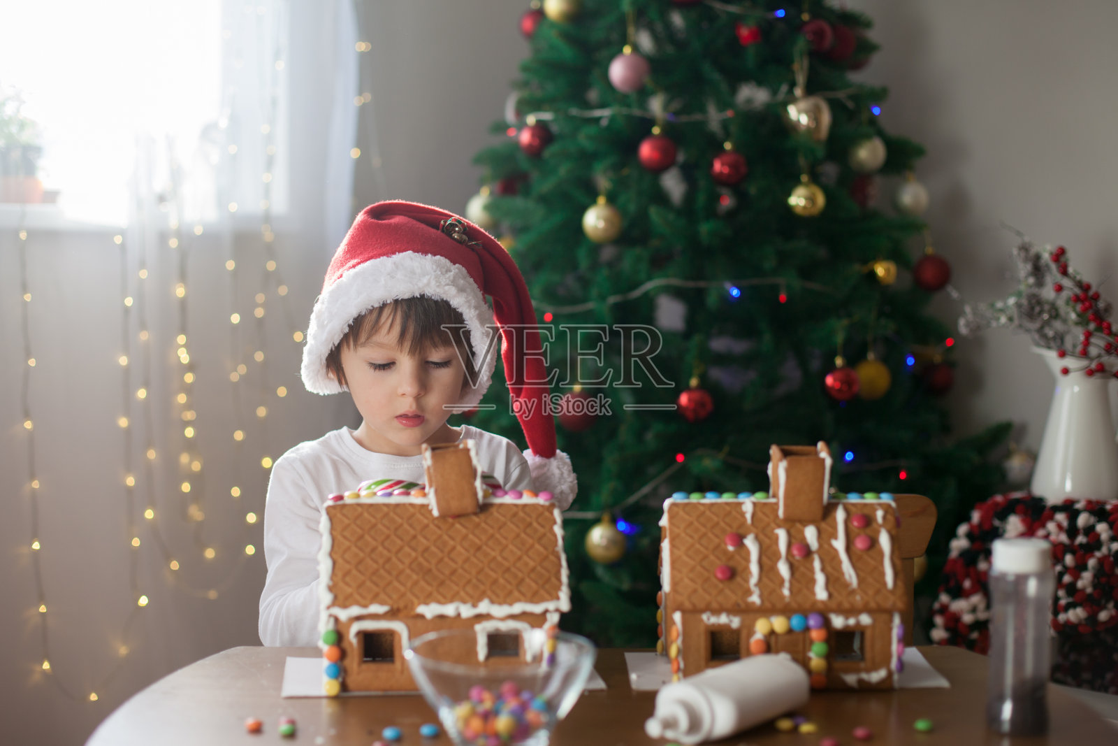 可爱的小男孩，为圣诞节做姜饼照片摄影图片