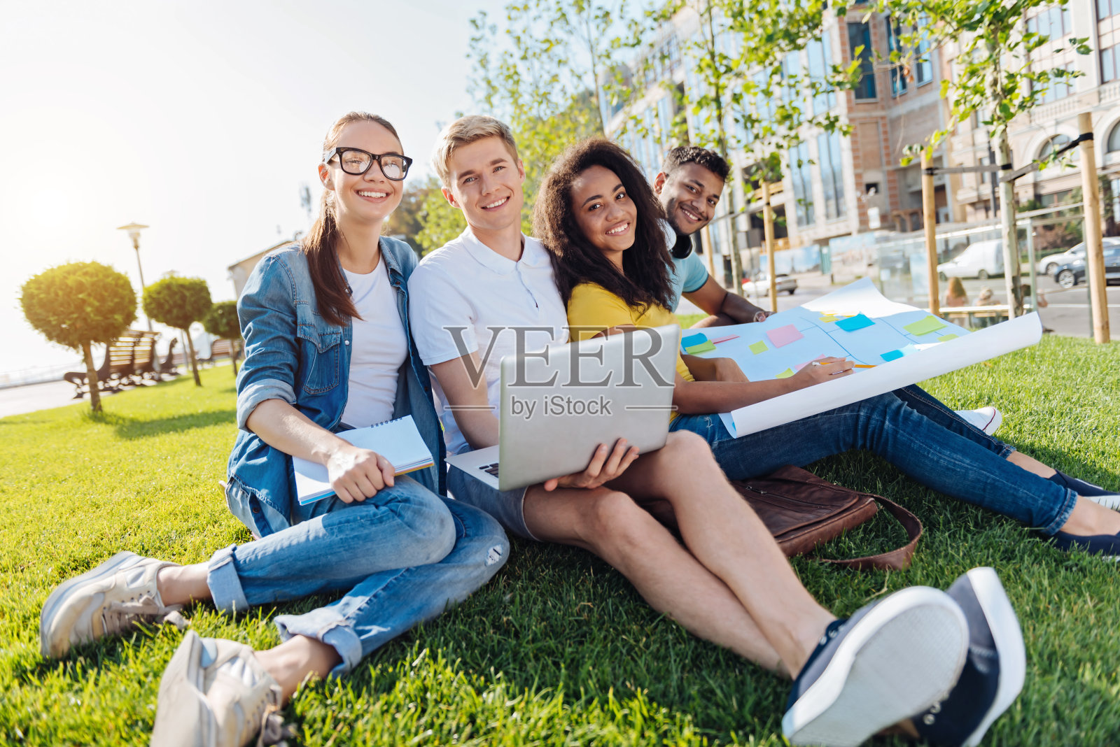 年轻人轻松地坐在草地上照片摄影图片