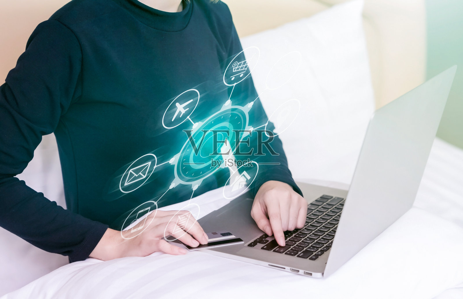 快乐的女人在床上网购。照片摄影图片