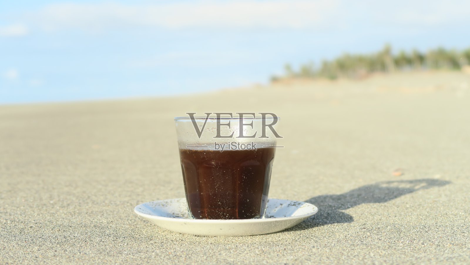 白色沙滩上的一杯阿拉比卡咖啡照片摄影图片
