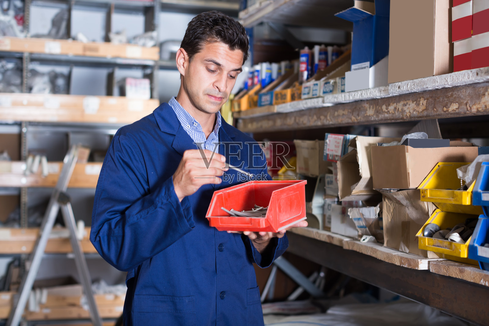 Workman正在检查盒子里的小细节照片摄影图片