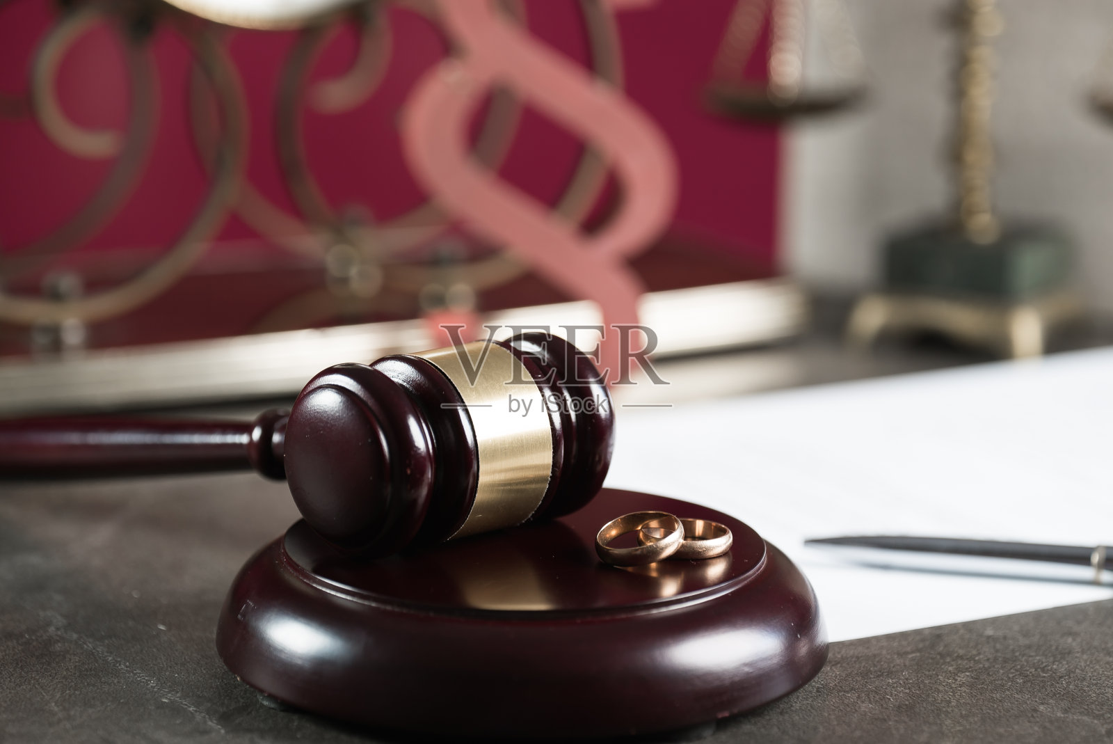 法庭桌上木槌旁的结婚戒指照片摄影图片