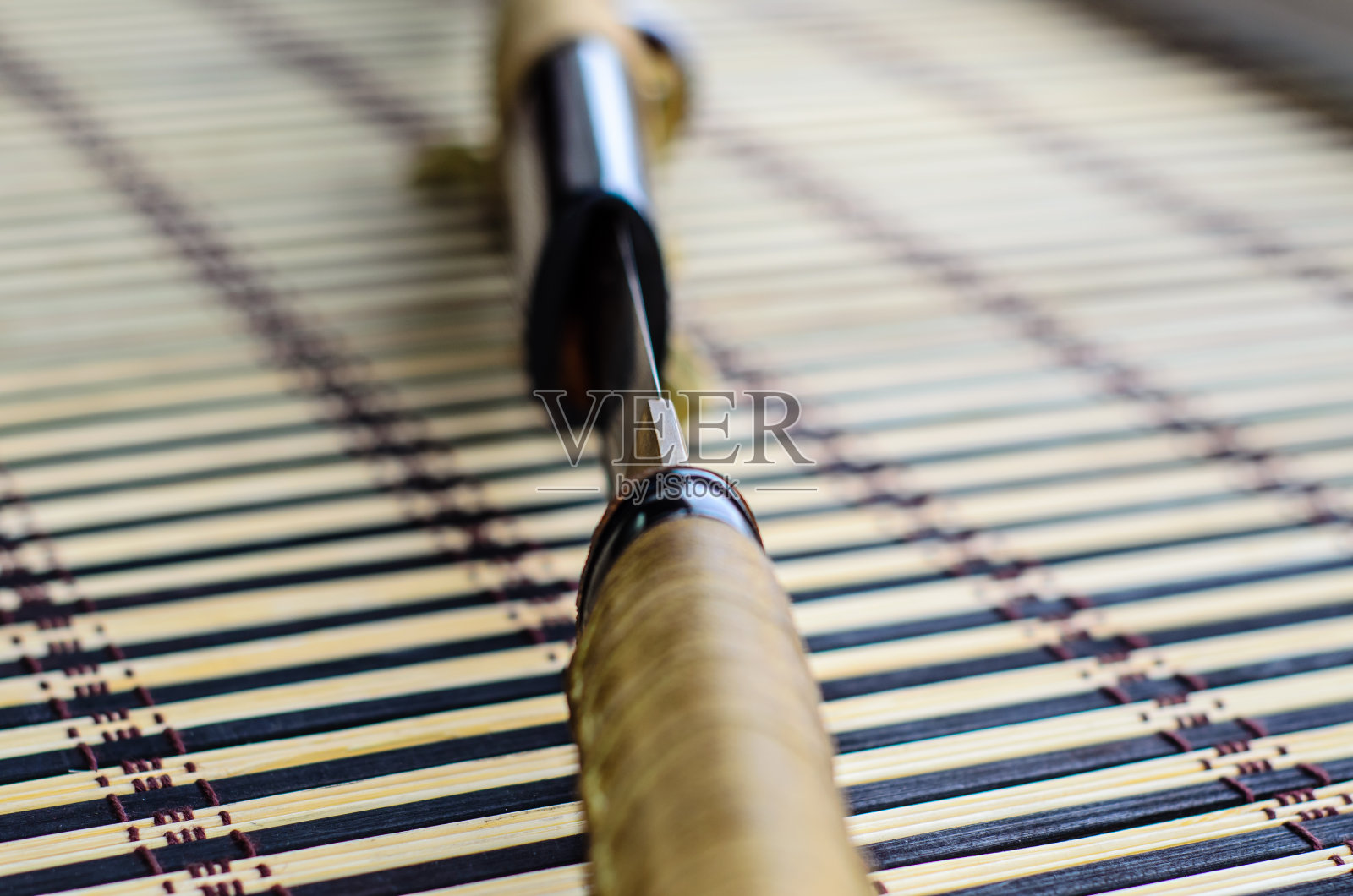 竹席上的日本武士刀。选择性聚焦照片摄影图片