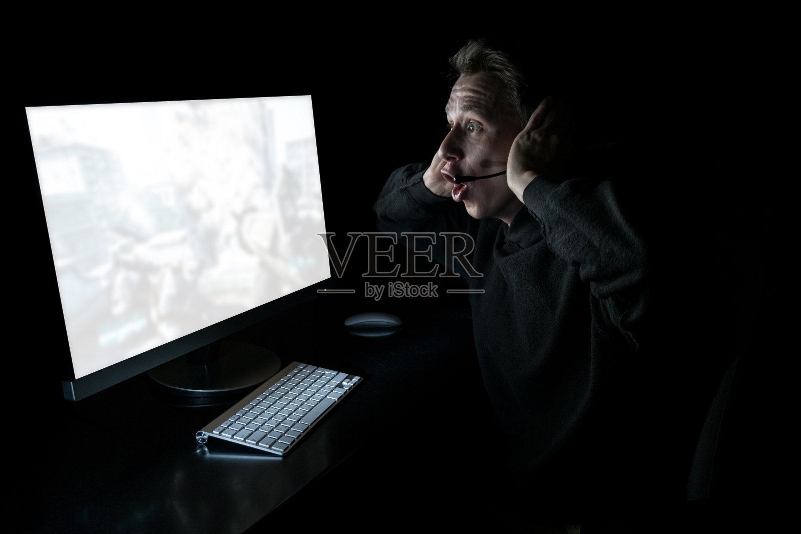 年轻玩家在暗室里玩游戏照片摄影图片