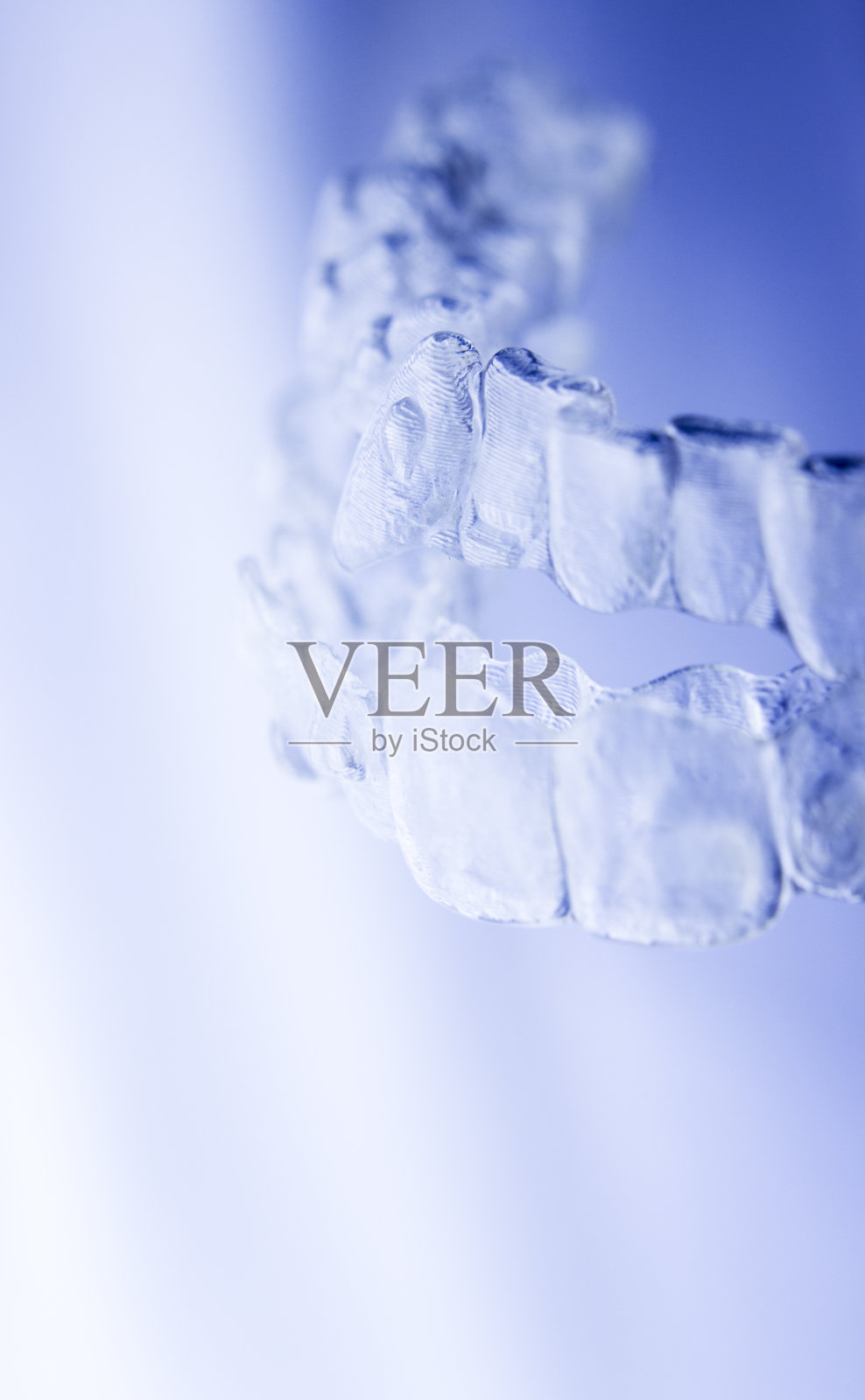 隐形牙齿矫正术，美容支架，牙齿矫正器，塑料支架，现代牙固位体隔离特写。照片摄影图片