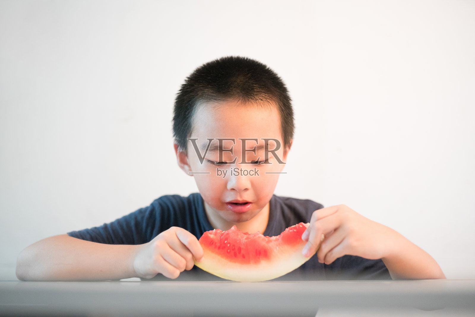 亚洲男孩坐在桌子前照片摄影图片