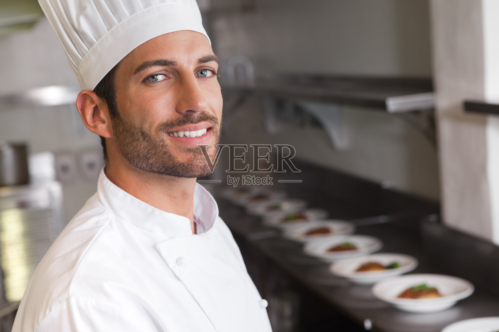 笑容可掬的年轻厨师对着镜头微笑照片摄影图片