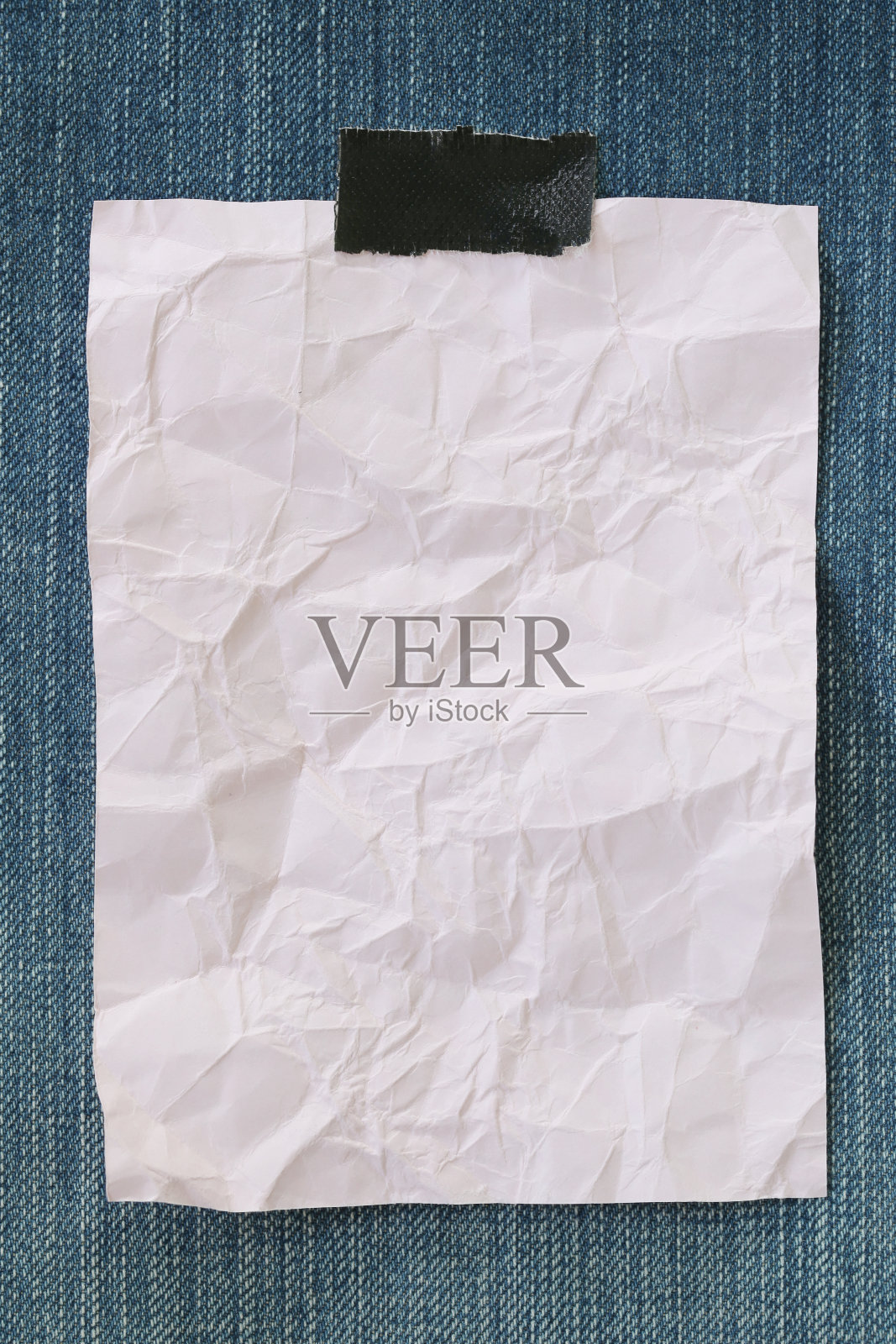 注意纸张皱巴巴的空白和牛仔布背景的复制空间。照片摄影图片