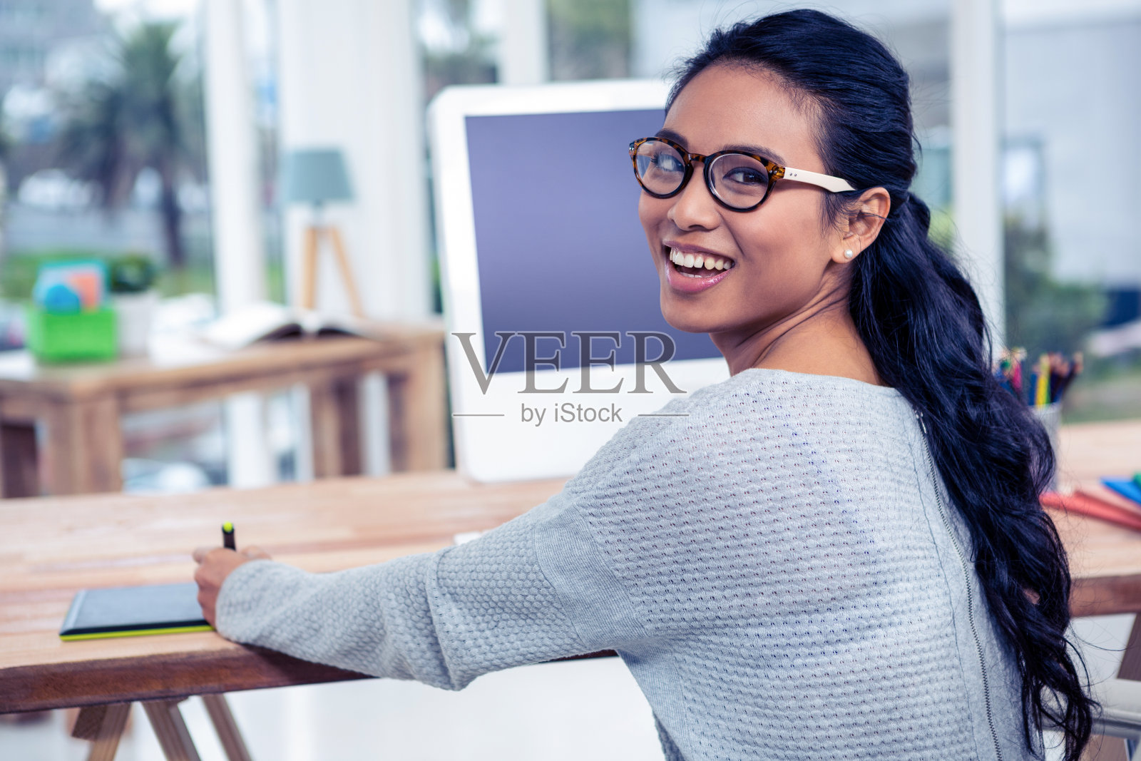 微笑的亚洲妇女使用数字板看回相机照片摄影图片