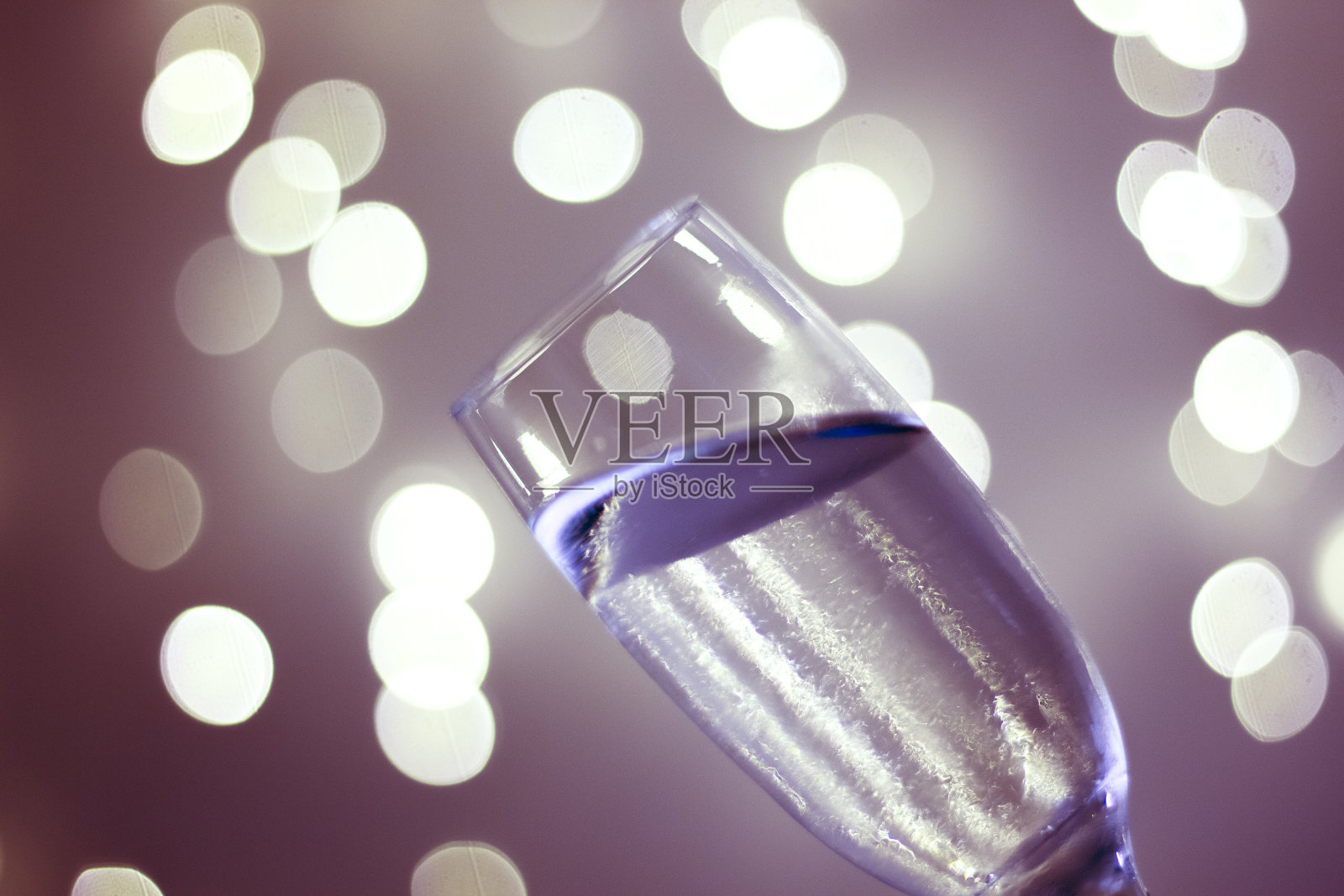 香槟起泡的酒杯在迪斯科派对晚上与分散的圣诞和新年灯光在夜总会照片摄影图片