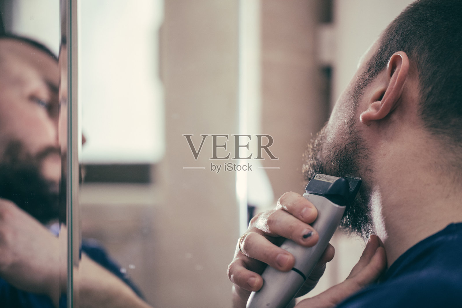 男人用电动剃须刀刮胡子照片摄影图片