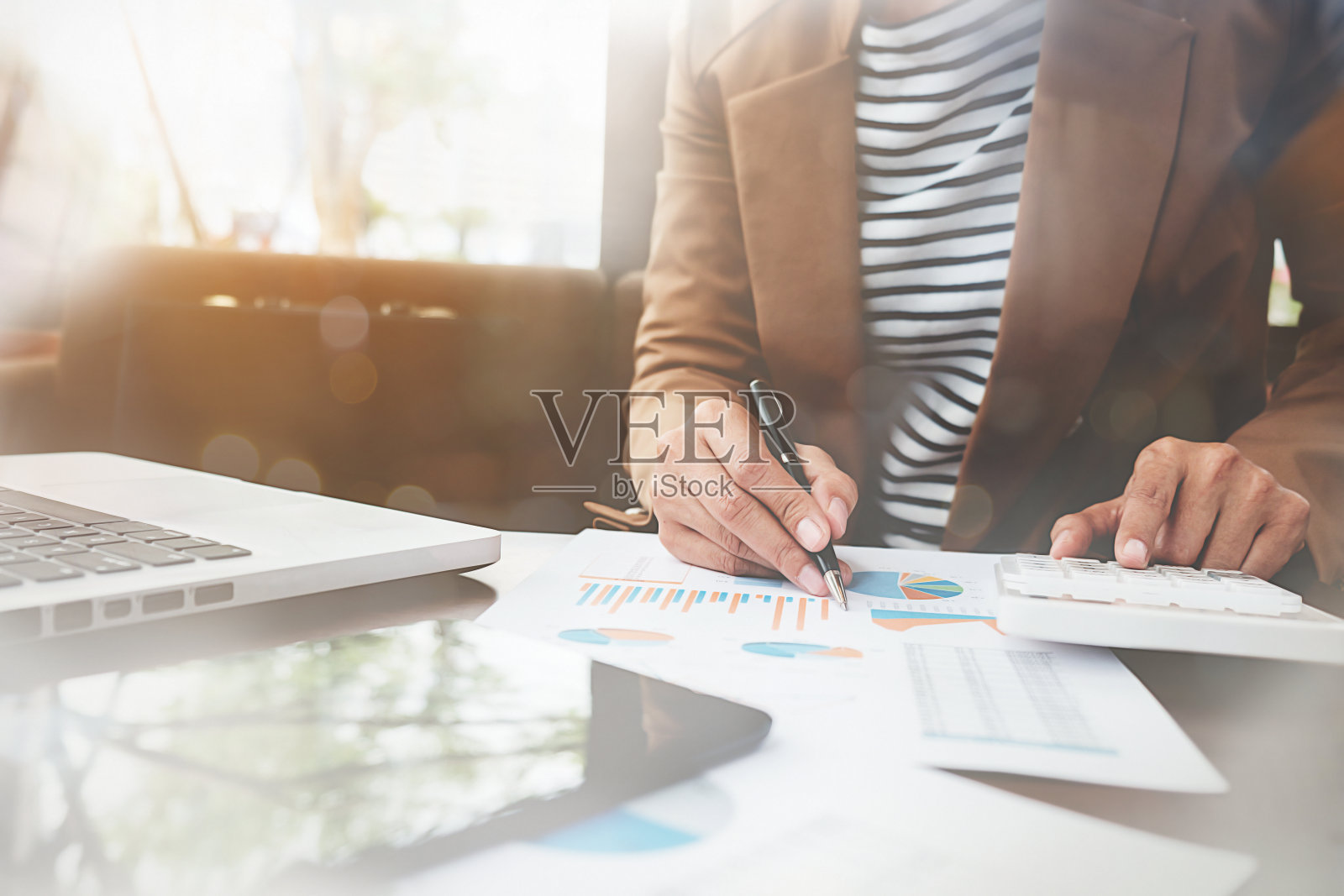 在办公室工作的女商人桌上放着笔记本电脑和文件。经营理念。照片摄影图片