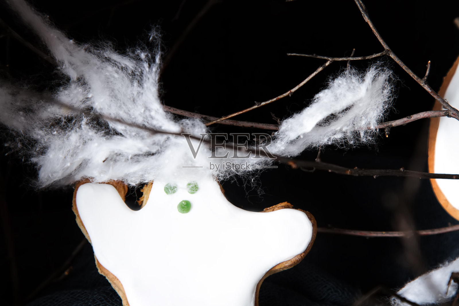 甜蜜的万圣节。鬼魂形状的饼干。黑暗的背景。空间的文本。照片摄影图片