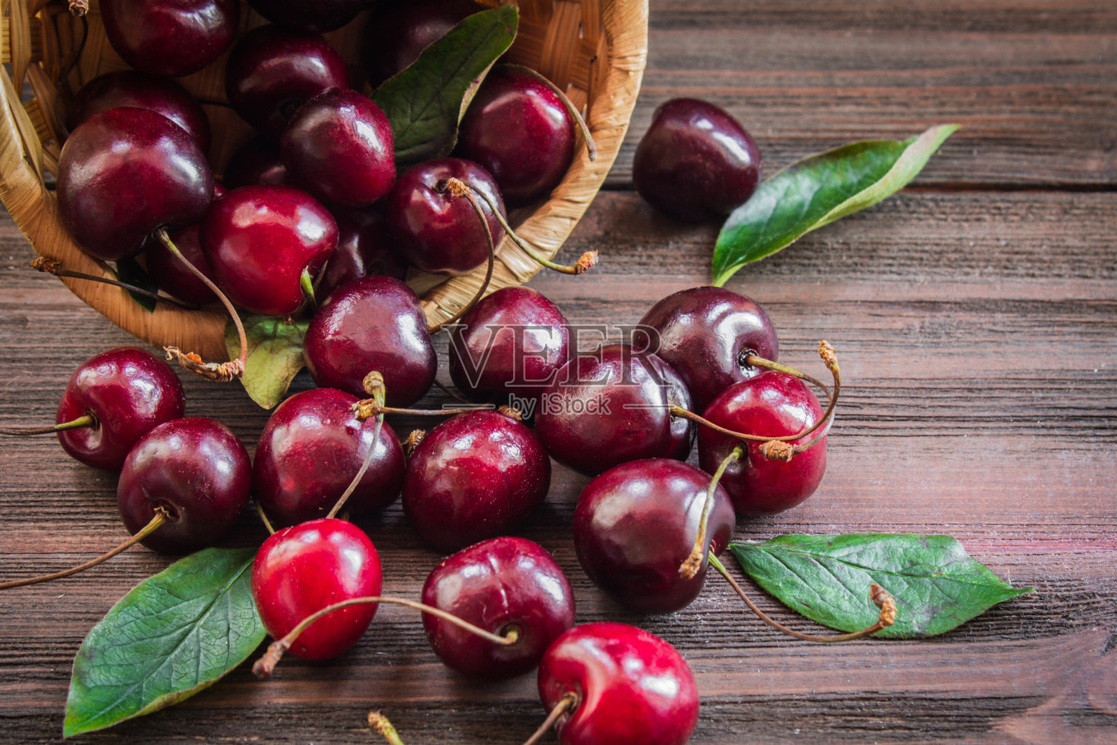 带叶子的樱桃放在篮子里睡足觉照片摄影图片