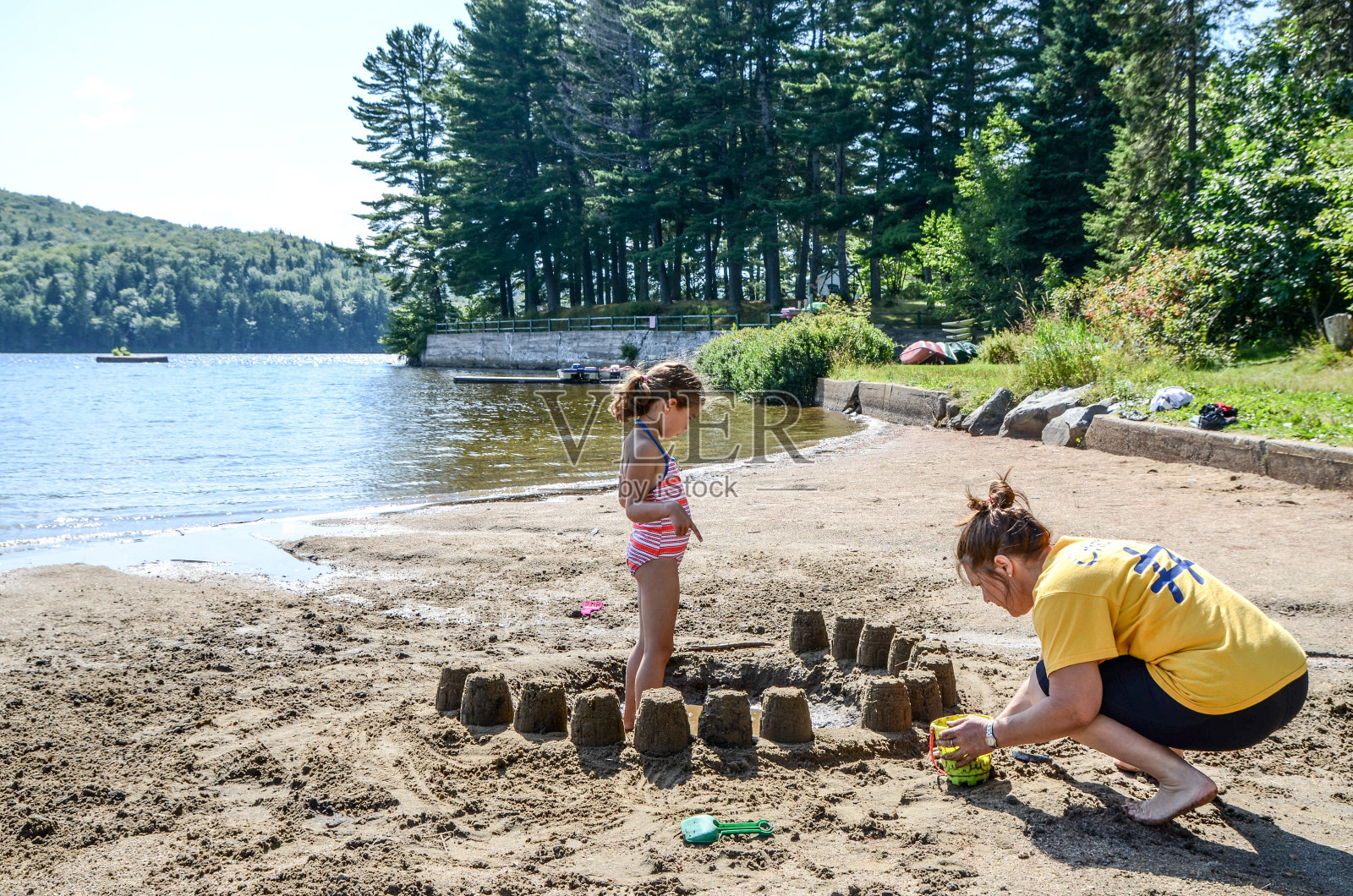 母女俩暑假在湖边做沙堡照片摄影图片