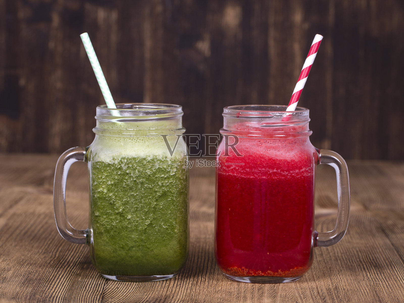 两杯由莳萝、花椰菜、香蕉和覆盆子混合而成的果汁奶昔放在木质背景上，特写照片摄影图片