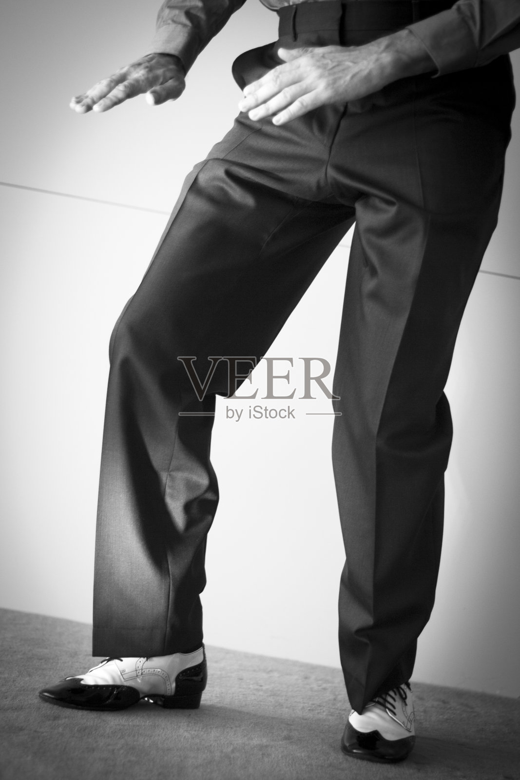 男拉丁和萨尔萨舞者在黑色和白色爵士舞鞋在光明和黑暗的舞台上照片摄影图片