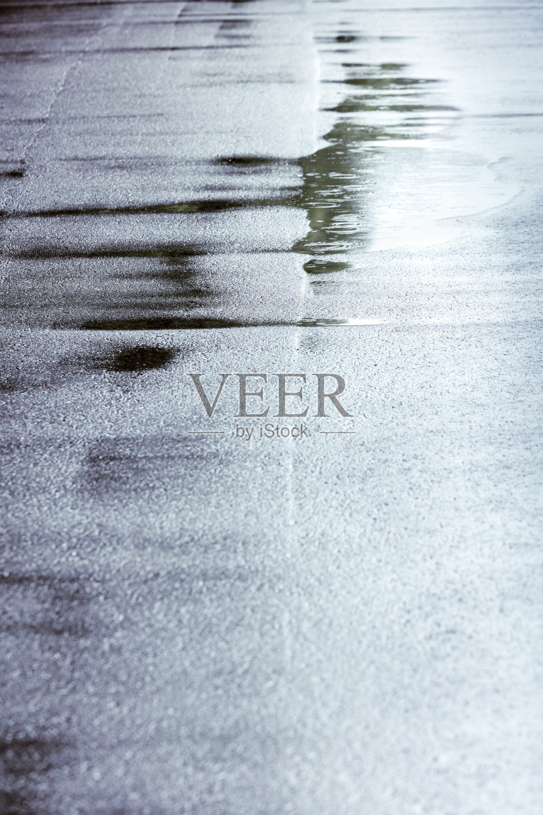 背景与雨滴和水的圆圈在黑暗的沥青照片摄影图片