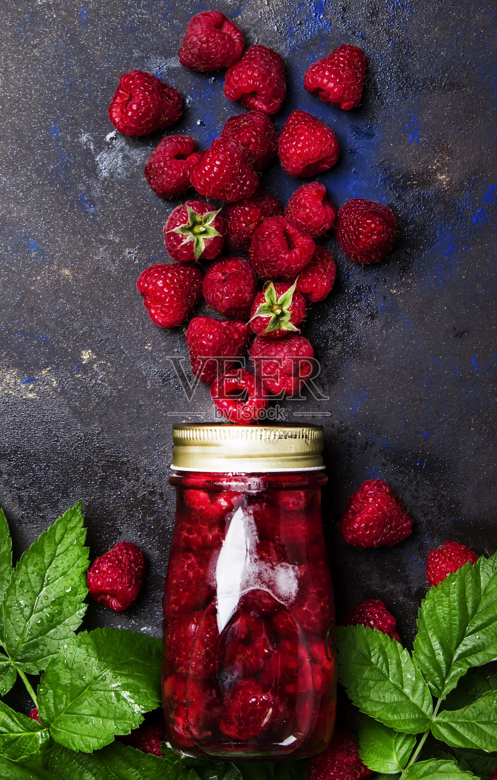 玻璃瓶中的覆盆子果盘照片摄影图片