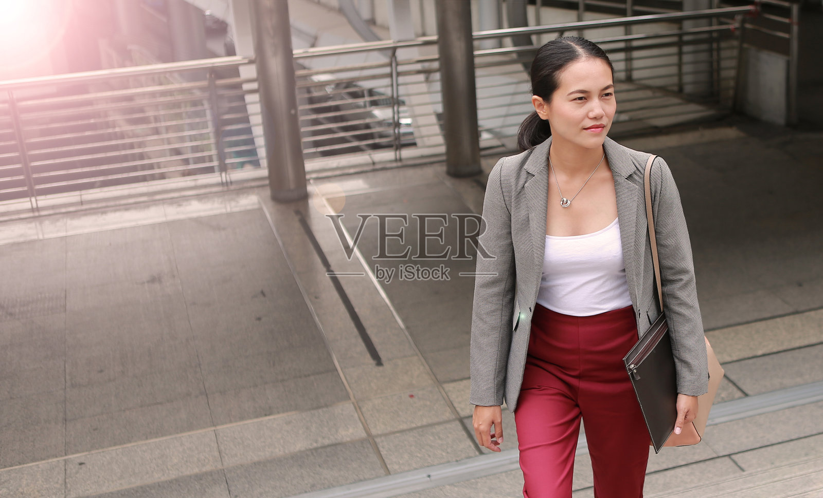 年轻漂亮的女商人走在外面。亚洲商业女性办公室职员在市中心商业区。照片摄影图片