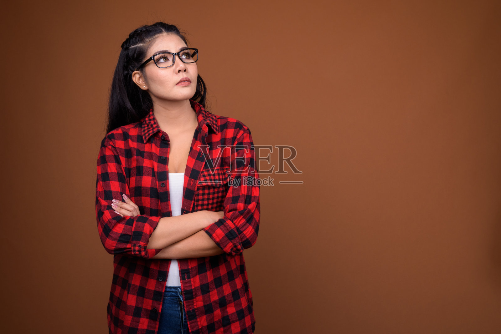 工作室拍摄的年轻美丽的亚洲女人穿着红色格子衬衫，以彩色的背景照片摄影图片