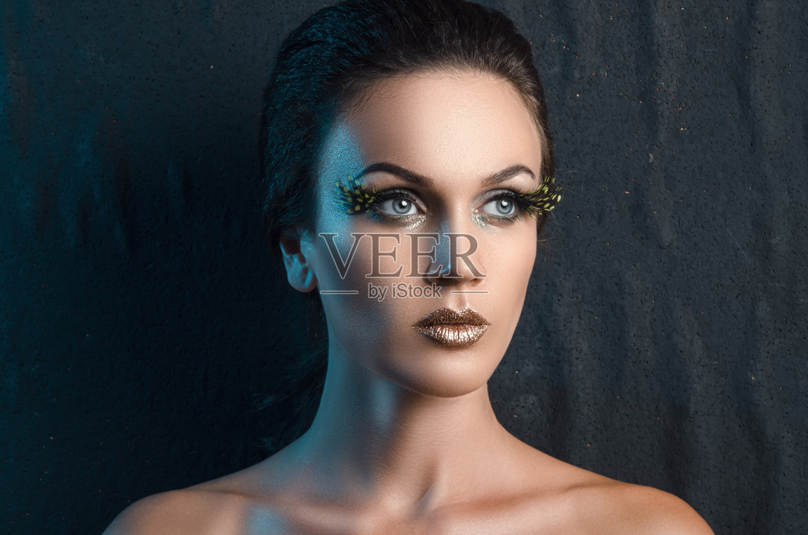 一个美丽的女人肖像的背景织物，蓝色的背光。照片摄影图片