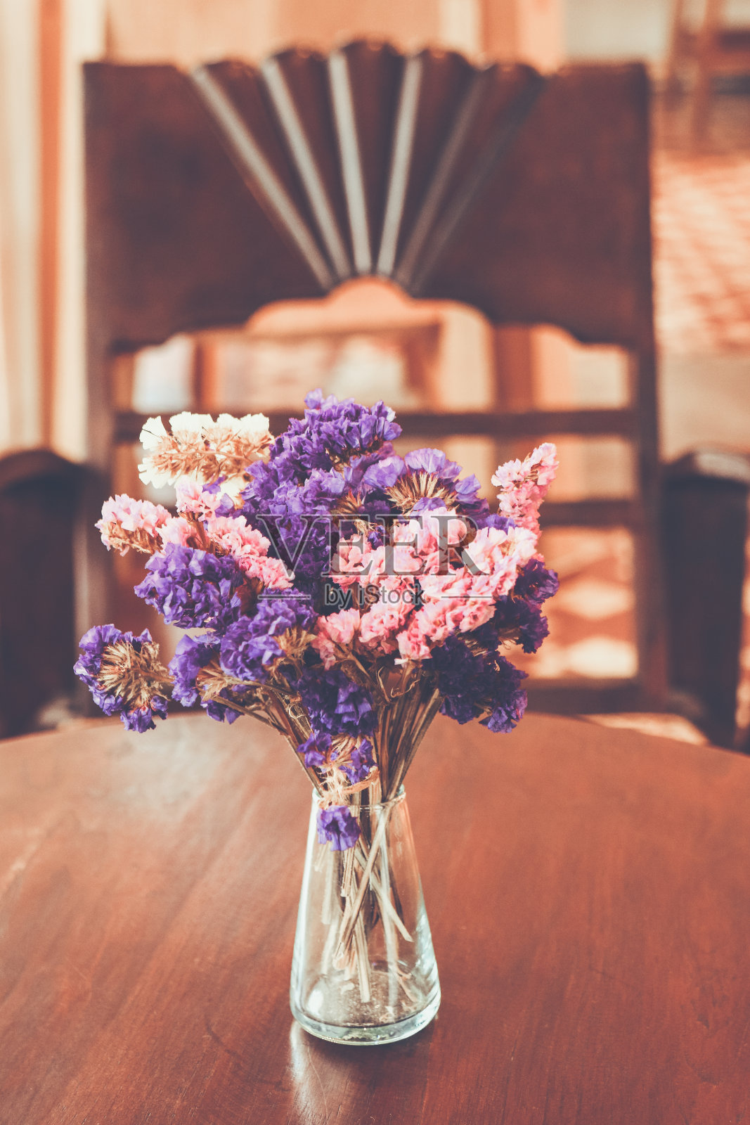 一束粉红色和紫色的花在玻璃花瓶在咖啡店，颜色复古风格模糊的背景，泰国照片摄影图片