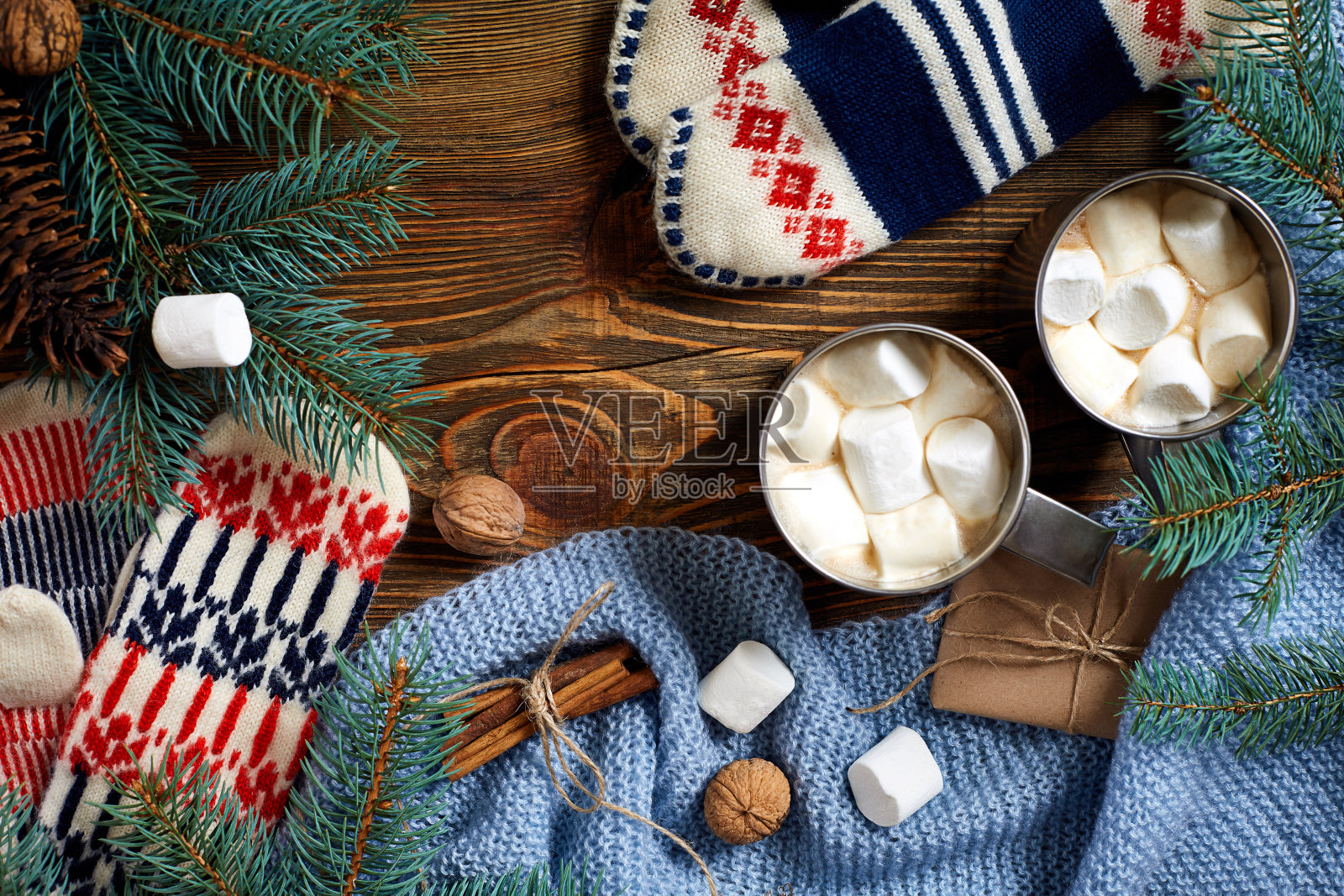 两杯热可可或巧克力，棉花糖，手套，圣诞装饰和冷杉树在木制的乡村背景从上面照片摄影图片