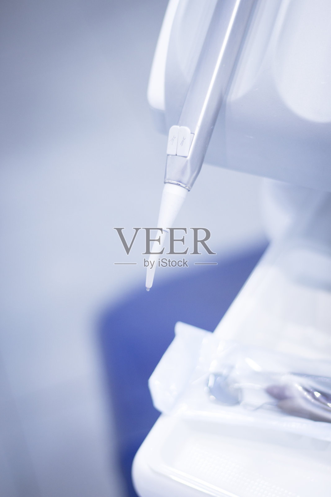 牙科医生在牙科诊所的椅子和钻头治疗病人的正畸。照片摄影图片