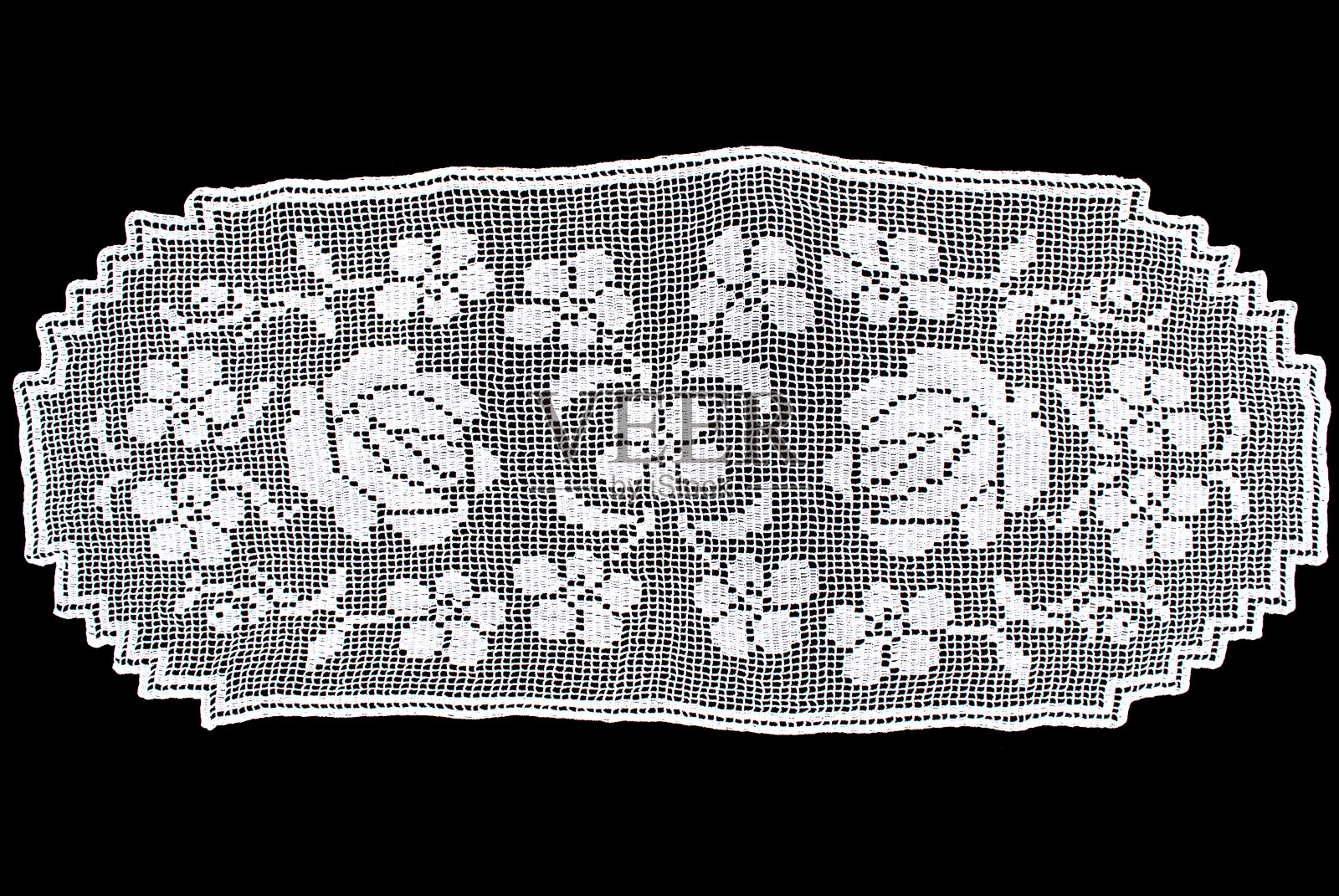 黑色背景上的白色椭圆形蕾丝桌布，花卉图案照片摄影图片