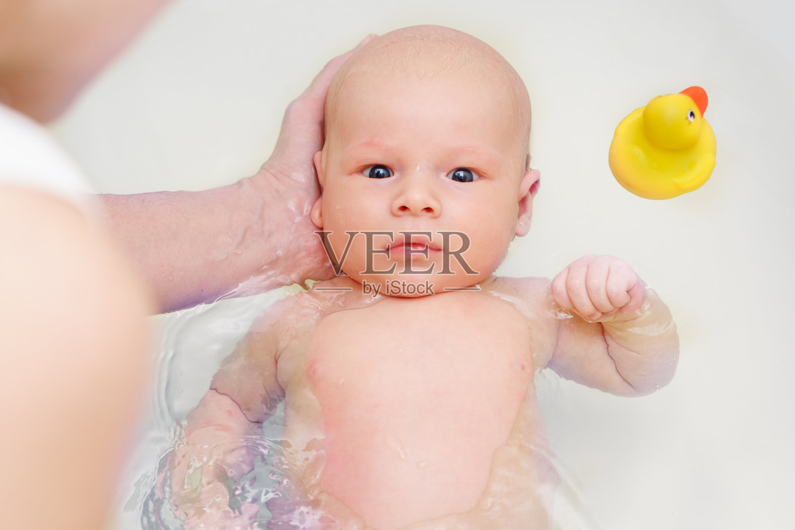 一名白人妇女抱着她刚出生的婴儿在水里洗澡照片摄影图片