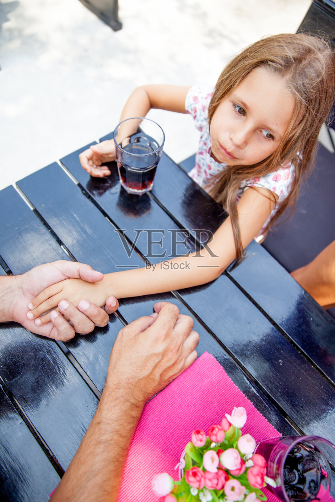 坐在桌边喝酒的时候，父亲和6岁的女儿愉快地聊天照片摄影图片