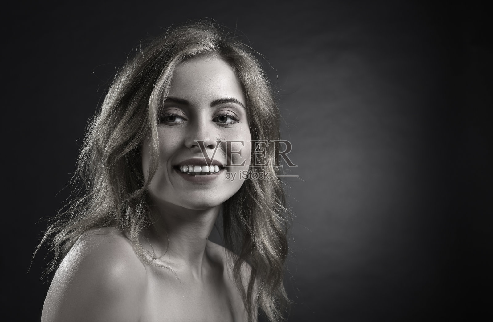 迷人的金发女人在黑暗的背景。照片摄影图片