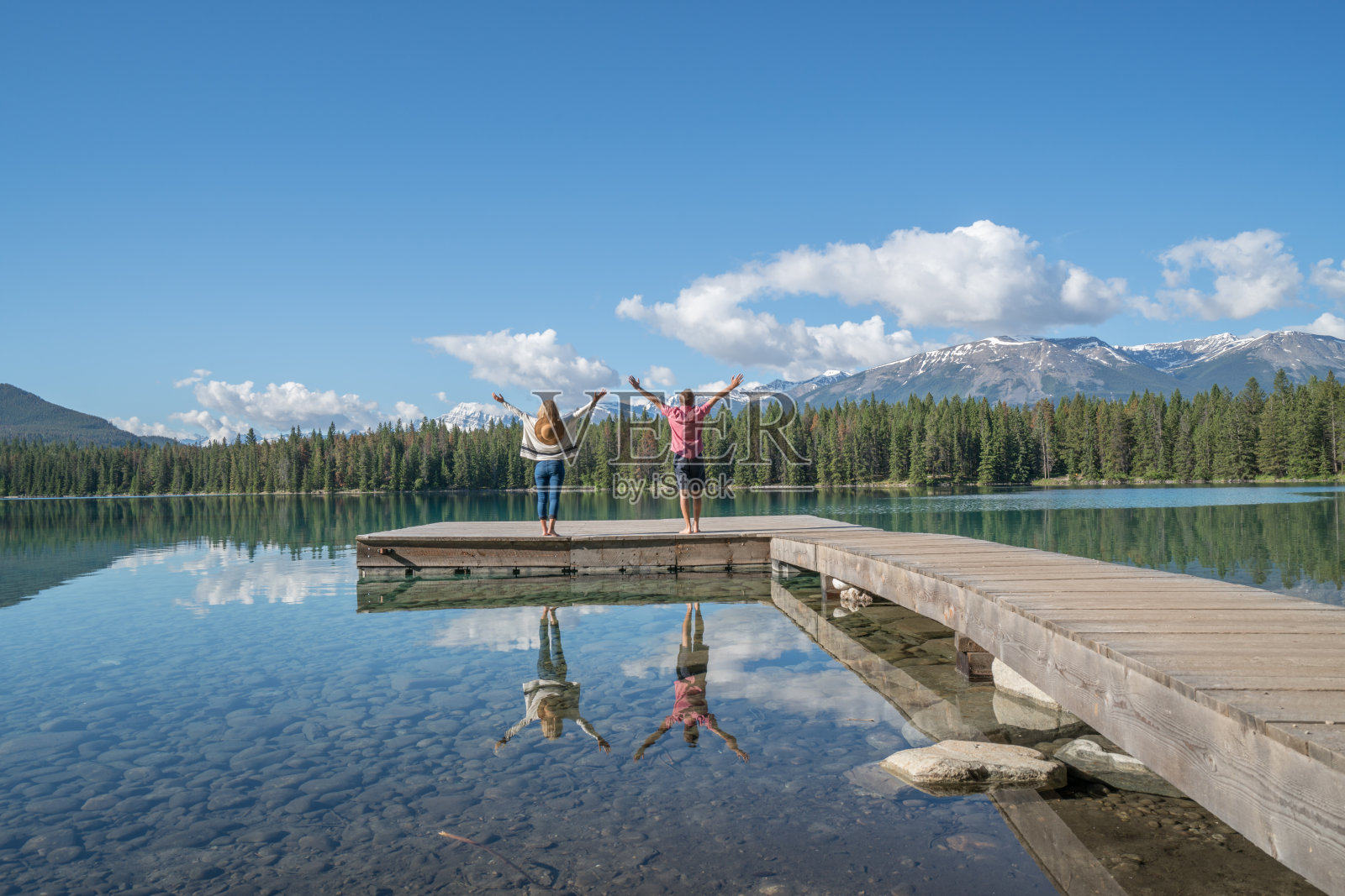 年轻夫妇张开双臂，欣赏山景照片摄影图片