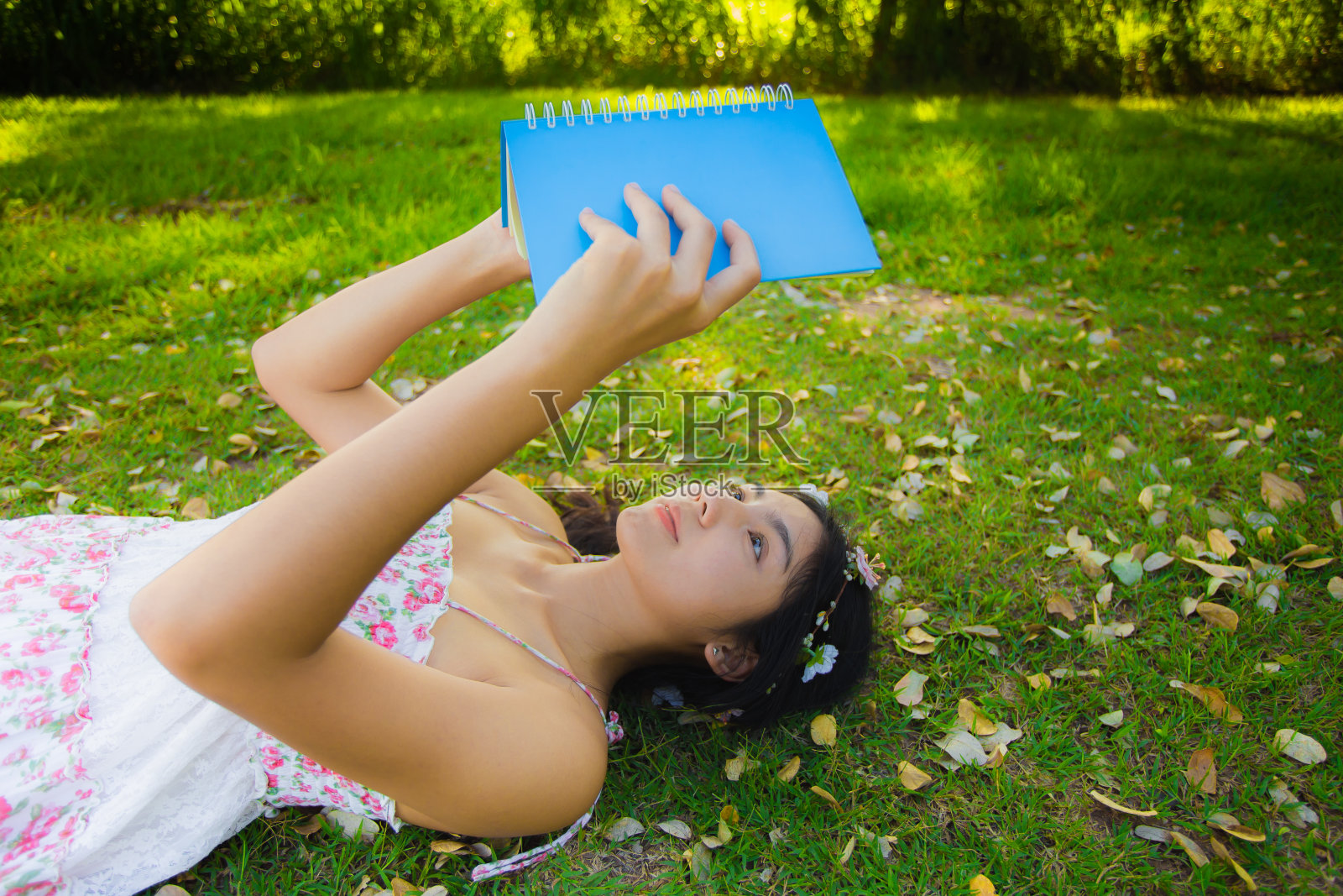 年轻的亚洲妇女在草地上野餐照片摄影图片