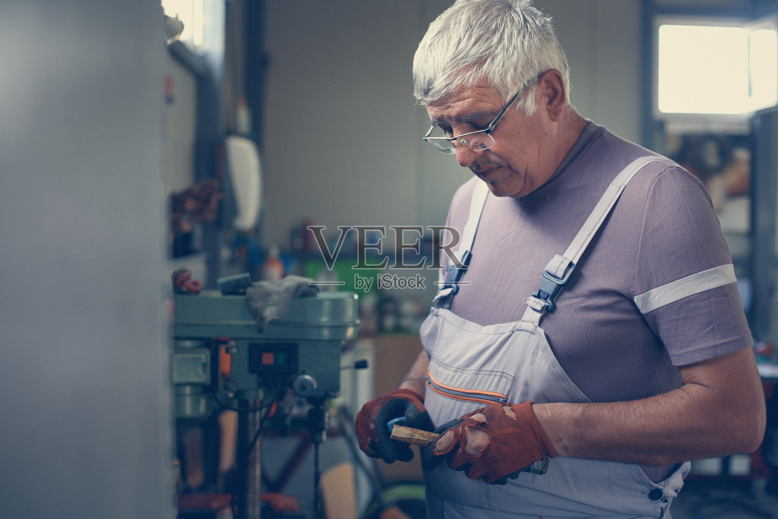 车间高级人员。人把木头。照片摄影图片